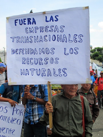 A protester at the May 20 demonstration in Guatemala City carries a sign reading "Out With Transnational Corporations; Let's Defend Our Natural Resources." Photo by Sandra Cuffe.
